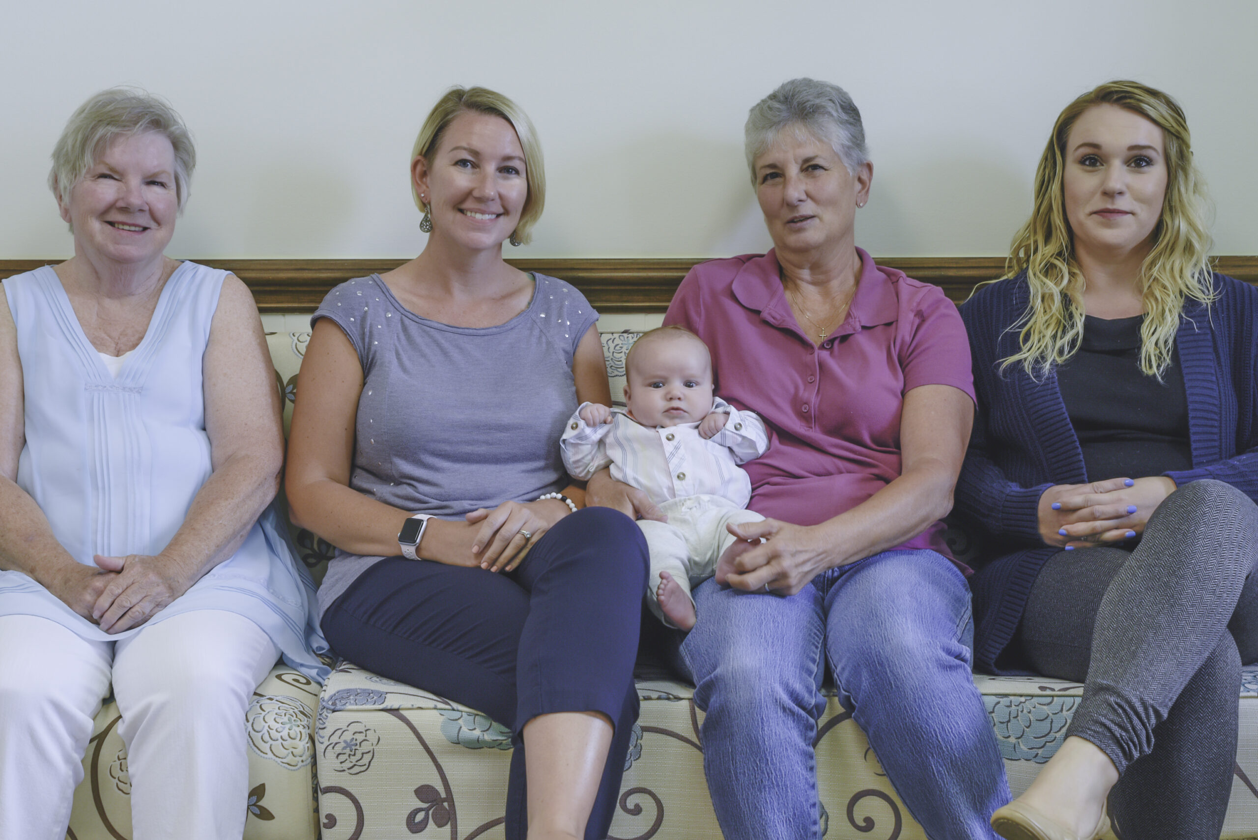 The Pro Tax & Accounting Team sitting on the couch with a baby including Andrea MacDonald, CPA, Sharon Ference, Whitney Schubert and Carma Boswell on the About us page.