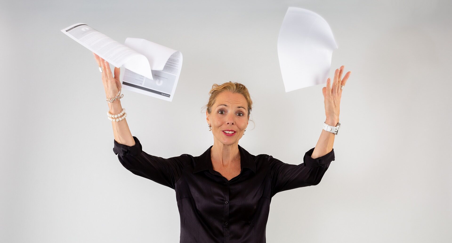 Woman in black throwing papers in the air frustrated needing help on Pro Tax & Accounting for bookkeeping